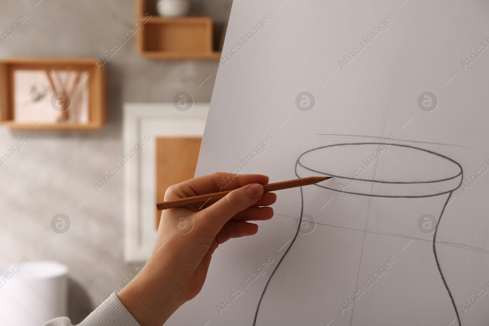 Photo of Woman drawing vase with graphite pencil on canvas indoors, closeup