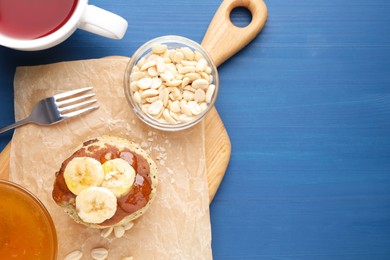 Photo of Banana pancakes with jam served on blue wooden table, flat lay. Space for text