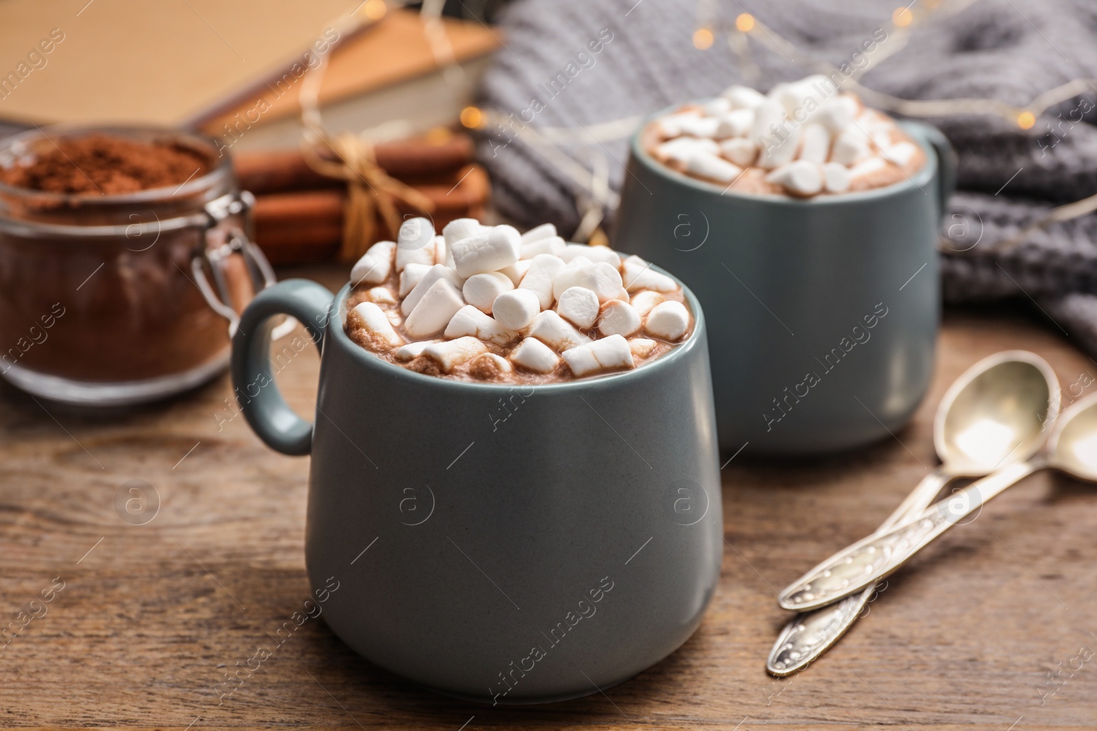 Photo of Cups of delicious hot cocoa with marshmallows on wooden table