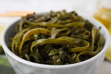 Photo of Tasty seaweed salad in bowl on table, closeup