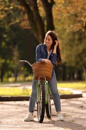 Photo of Beautiful young woman with bicycle in park