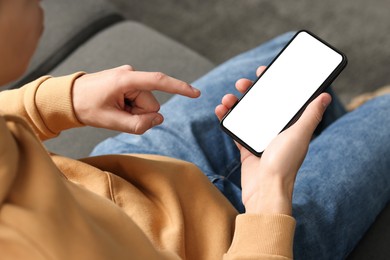 Photo of Man using smartphone with blank screen indoors, closeup. Mockup for design