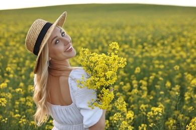 Portrait of happy young woman in field on spring day