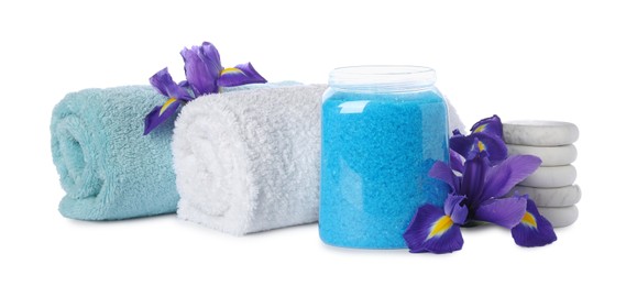 Glass jar with light blue sea salt, towels and beautiful flowers on white background