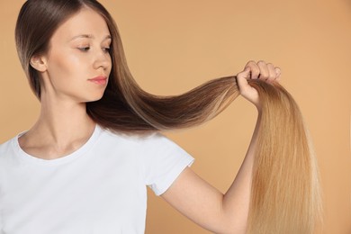 Photo of Teenage girl with strong healthy hair on beige background