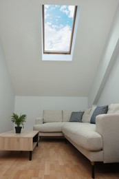 Photo of Attic room interior with slanted ceiling and furniture