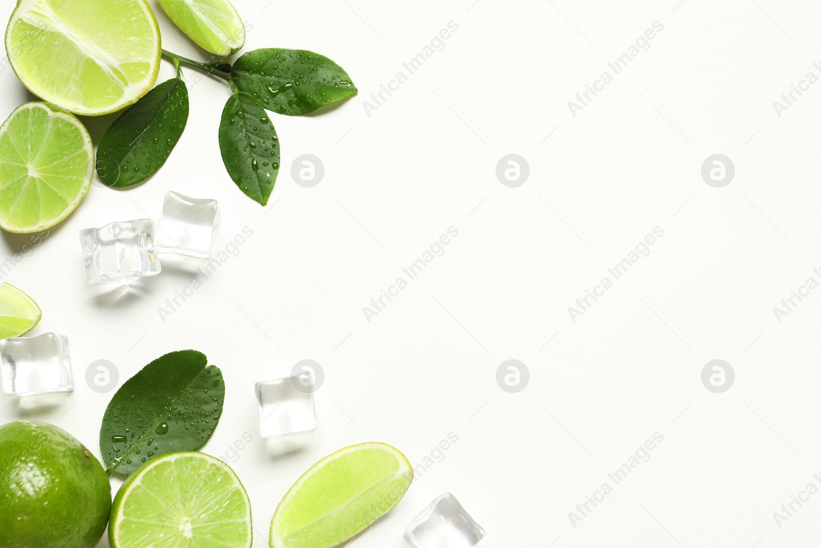 Photo of Fresh ripe limes with green leaves and ice cubes on white background, flat lay