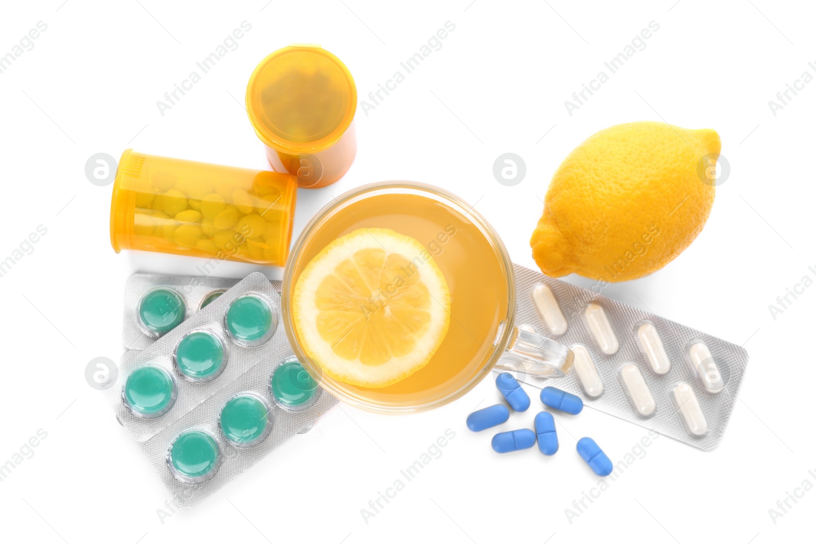 Photo of Hot tea with lemon, pills and drugs for cold on white background