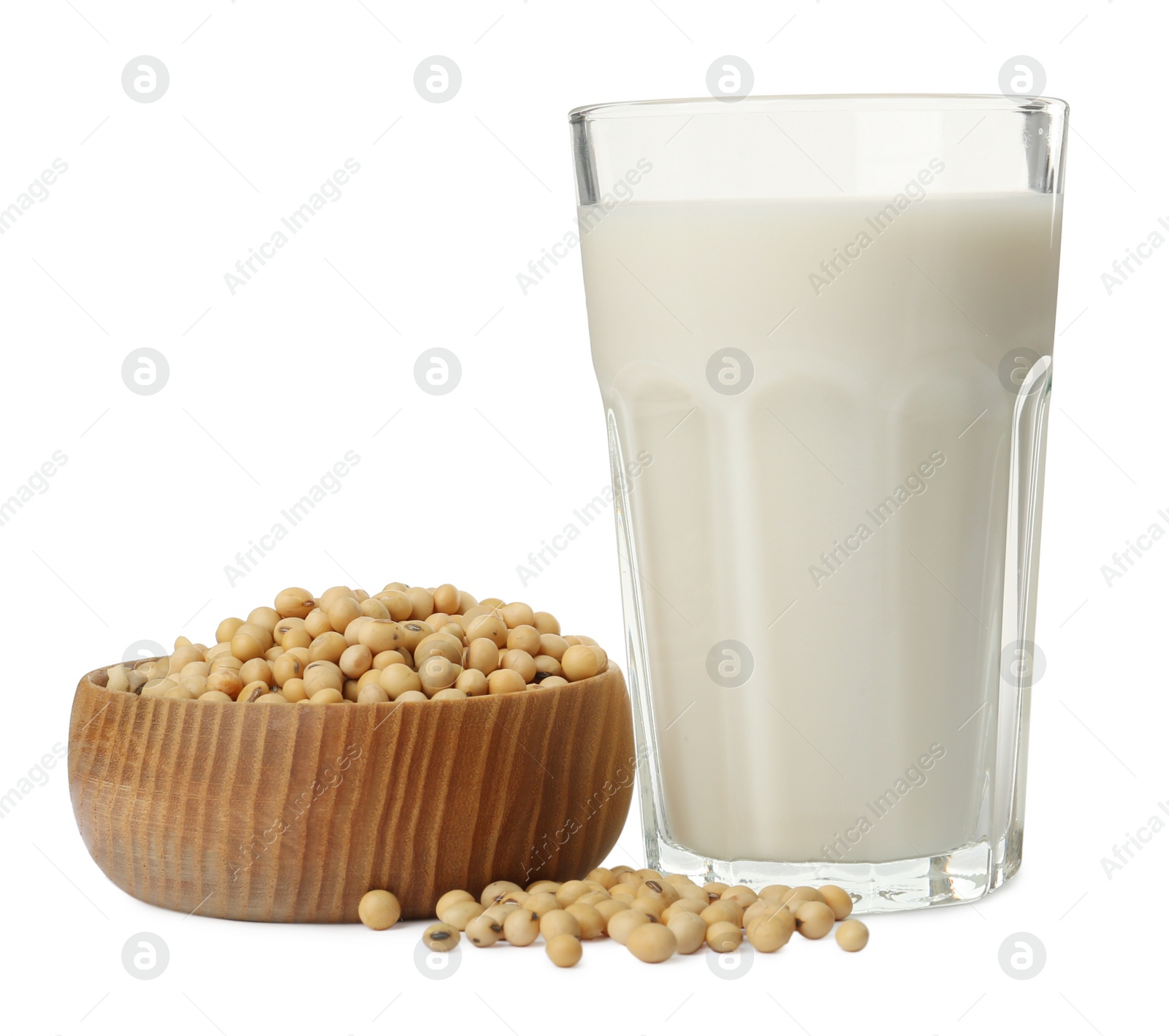 Photo of Glass of fresh soy milk and bowl with beans on white background