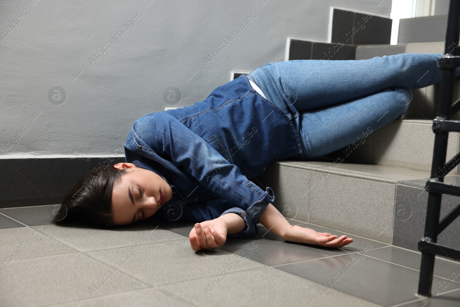 Photo of Unconscious woman lying on floor after falling down stairs indoors