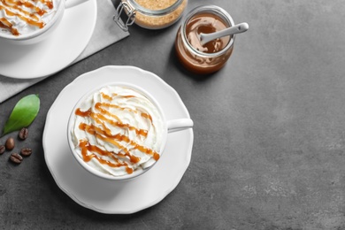 Photo of Cups of coffee with caramel topping on grey background, top view