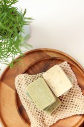 Soap bars and houseplant on white table, flat lay and space for text. Spa time