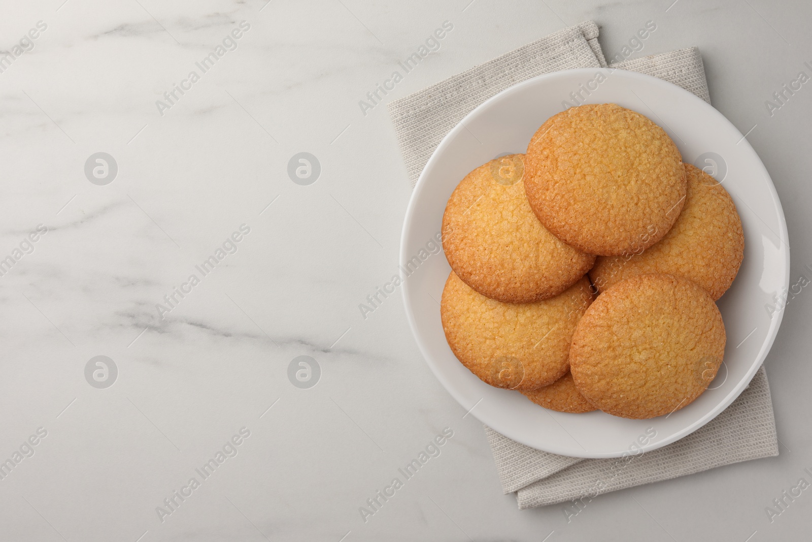 Photo of Delicious Danish butter cookies on white marble table, top view. Space for text