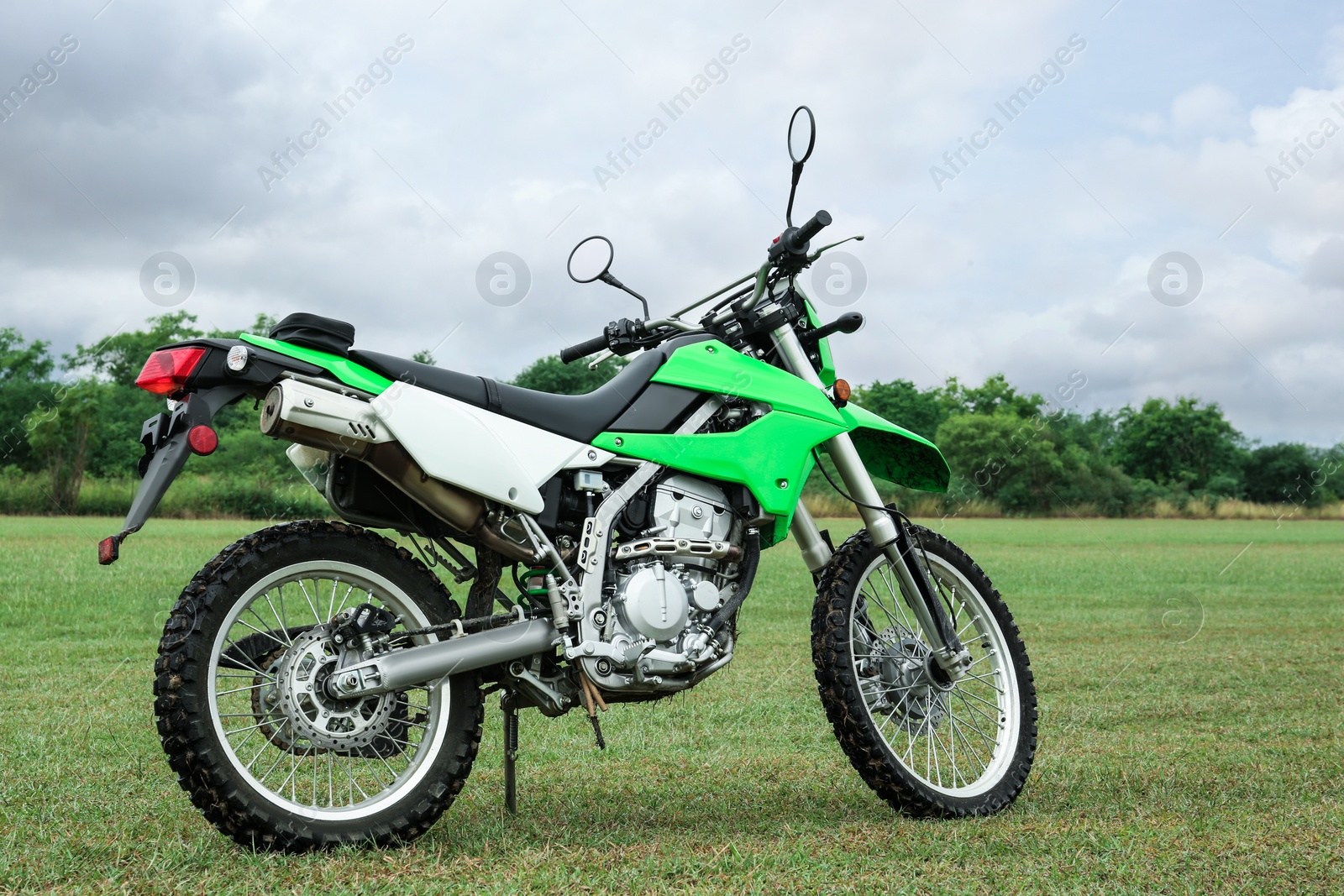 Photo of Stylish cross motorcycle on green grass outdoors