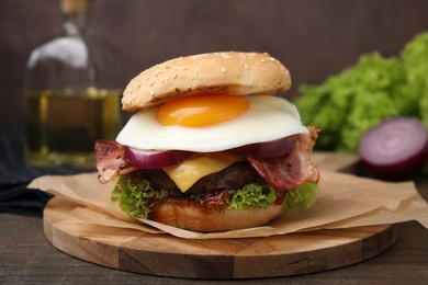 Photo of Delicious burger with fried egg on wooden table