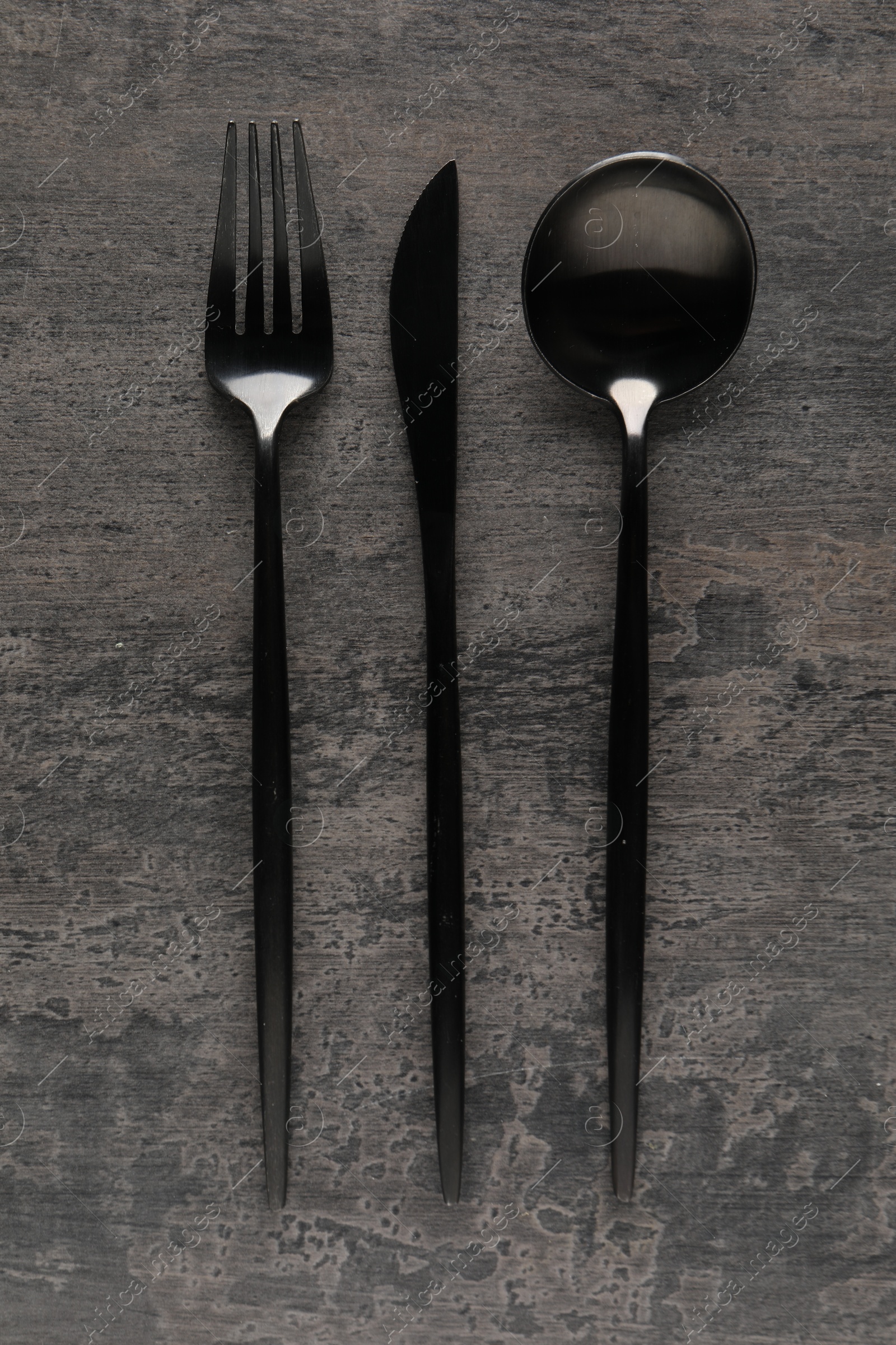 Photo of Stylish cutlery on grey table, flat lay