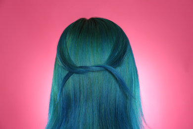 Photo of Woman with bright dyed hair on pink background, back view