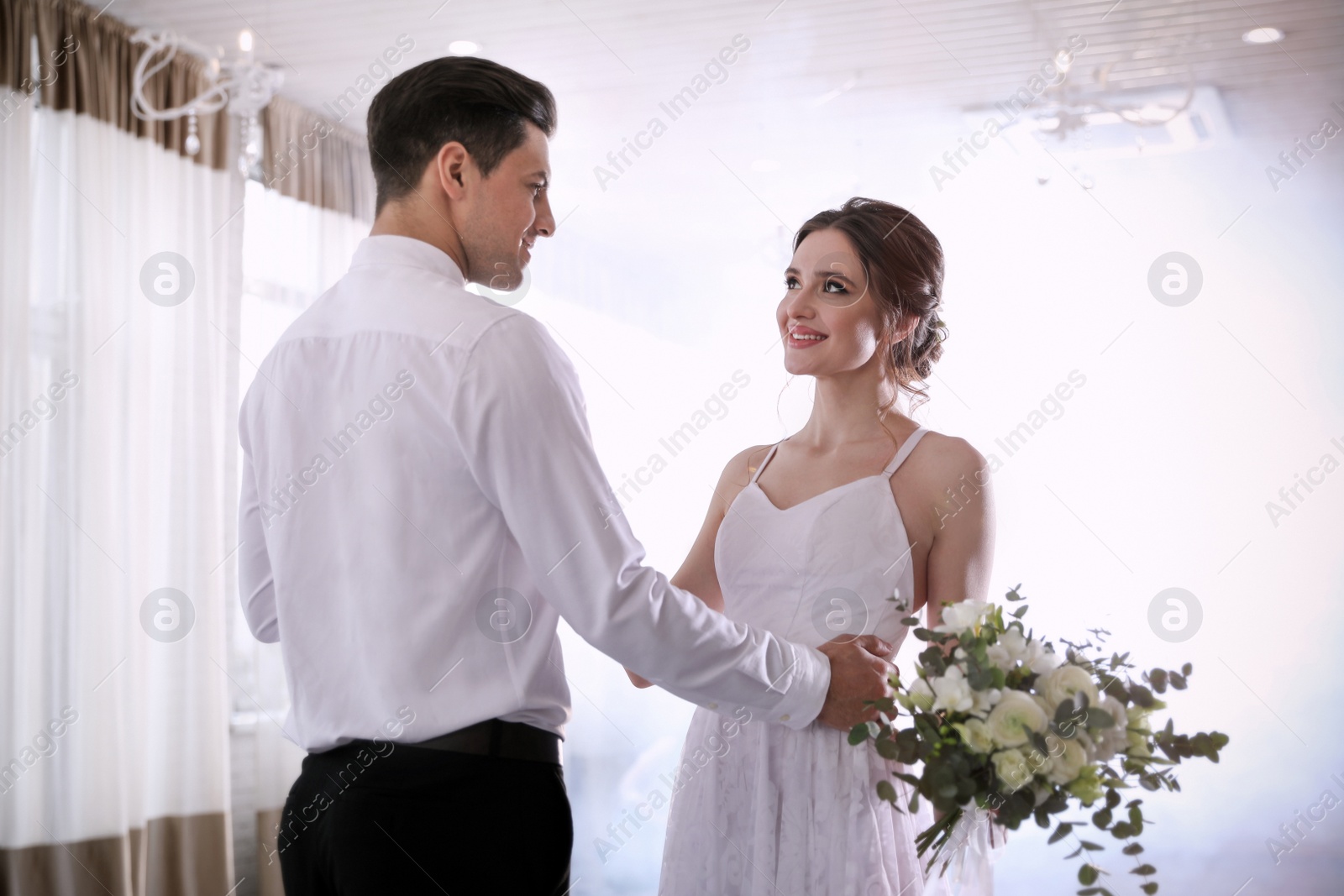 Photo of Happy newlywed couple dancing together in festive hall