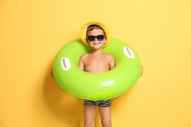 Photo of Cute little boy with inflatable ring on color background