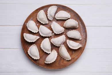 Photo of Raw dumplings (varenyky) on white wooden table, top view