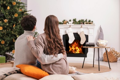 Couple watching movie via video projector at home, back view