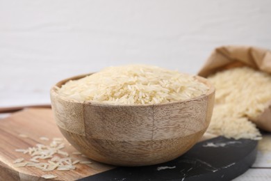 Raw rice in bowl on table, closeup