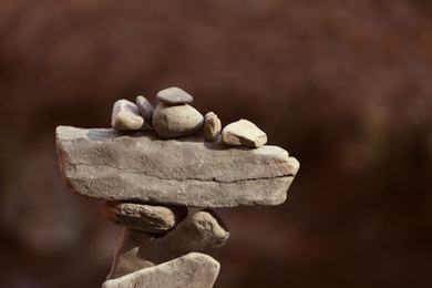 Photo of Tower of balancing stones against blurred background. Space for text