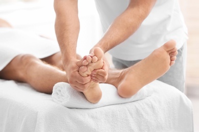 Photo of Young woman receiving massage in salon, closeup