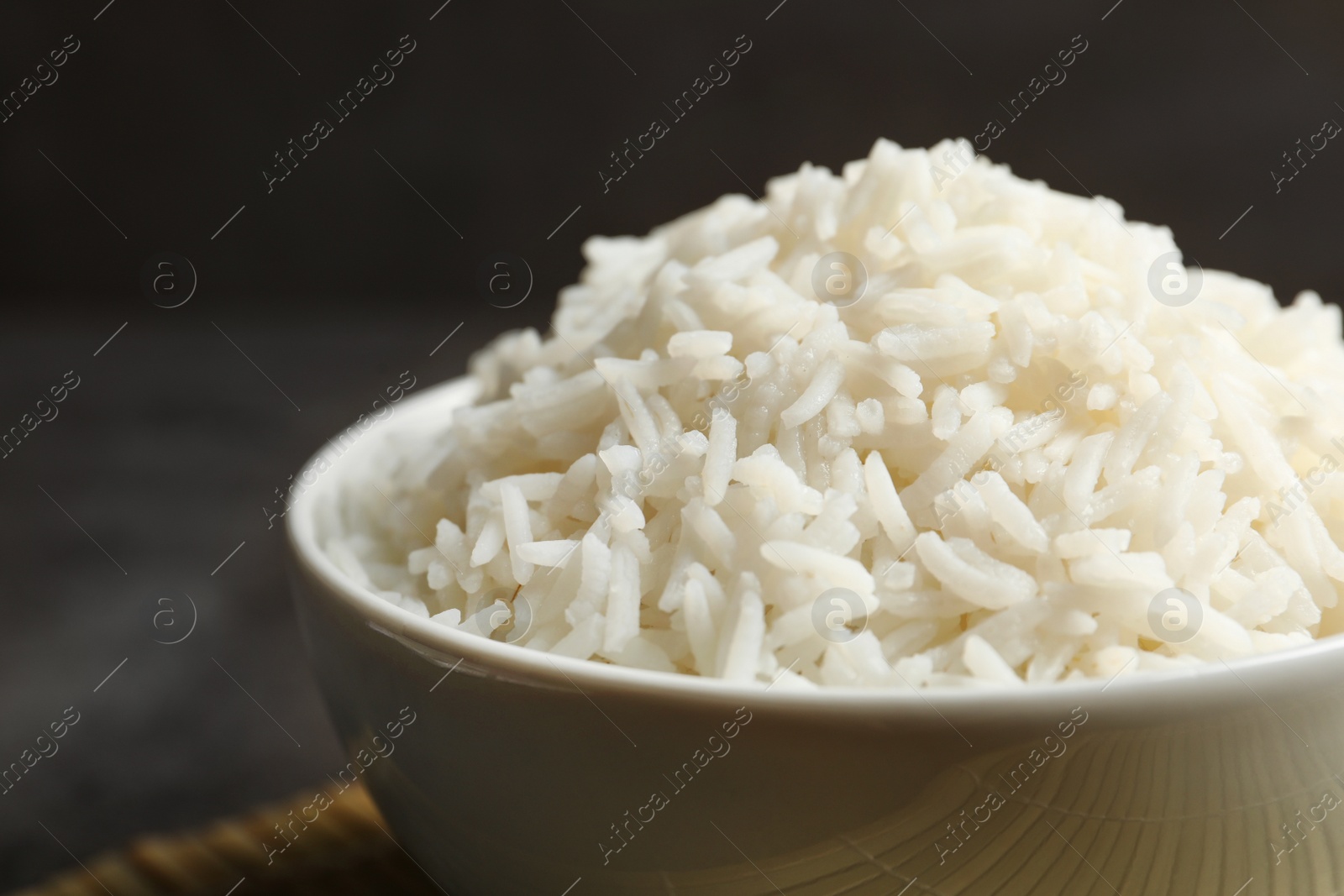 Photo of Bowl of tasty cooked white rice on table, closeup