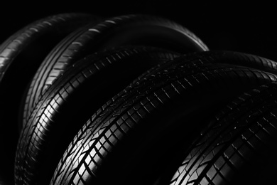 New car tires on black background, closeup