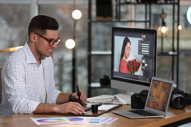 Professional retoucher working on computer in office