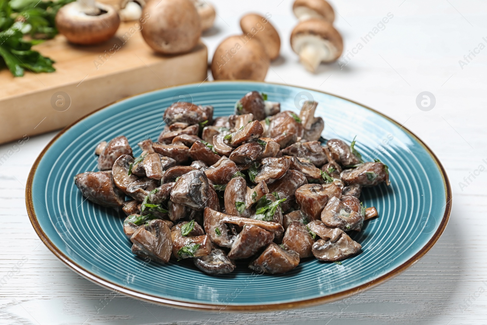 Photo of Plate of tasty fried mushrooms with sauce on table