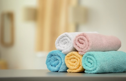 Photo of Clean towels on table against blurred background