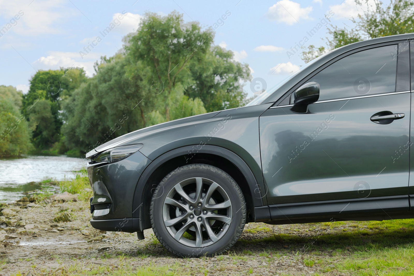 Photo of New black modern car on ground near river