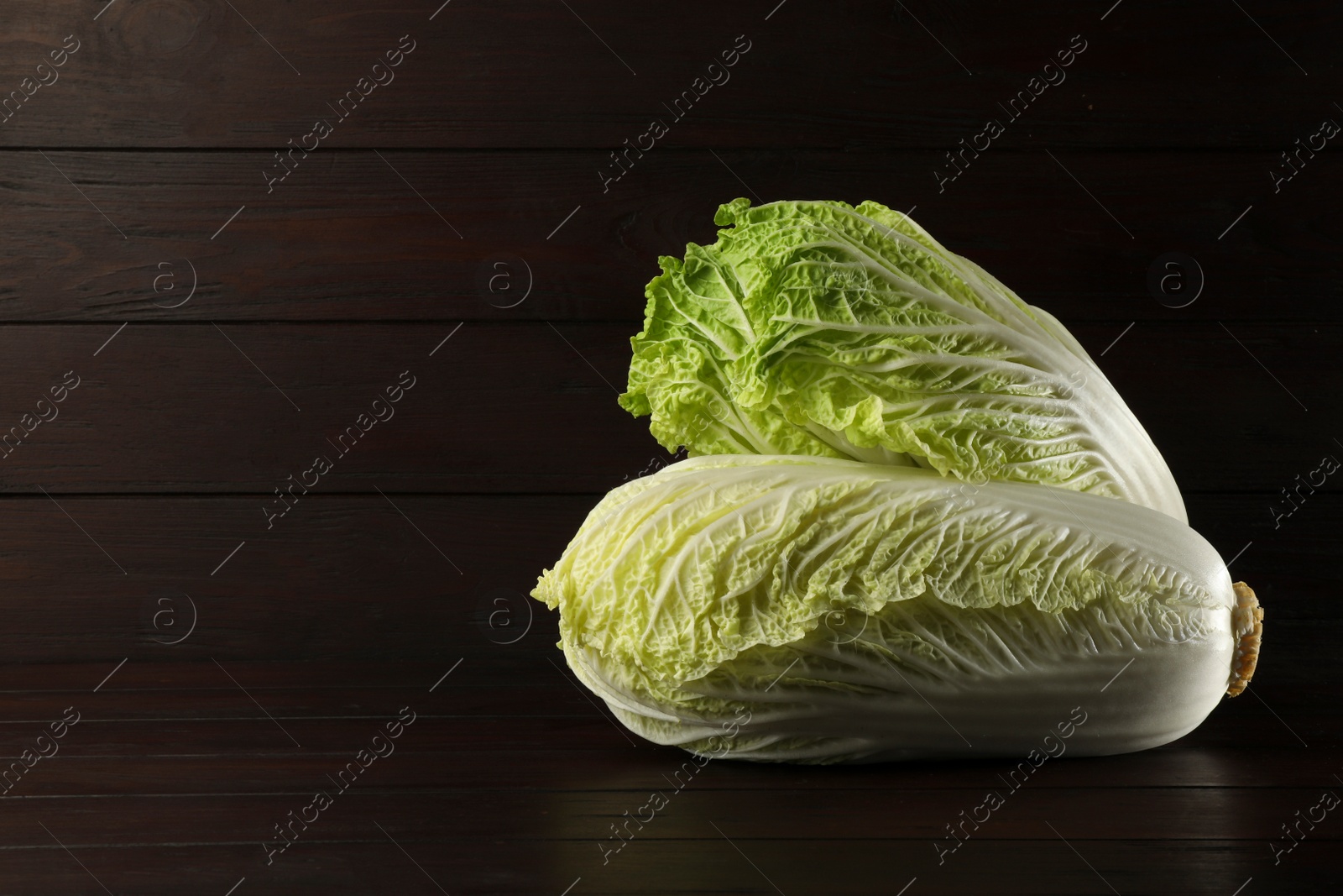 Photo of Fresh ripe Chinese cabbages on table against wooden background. Space for text