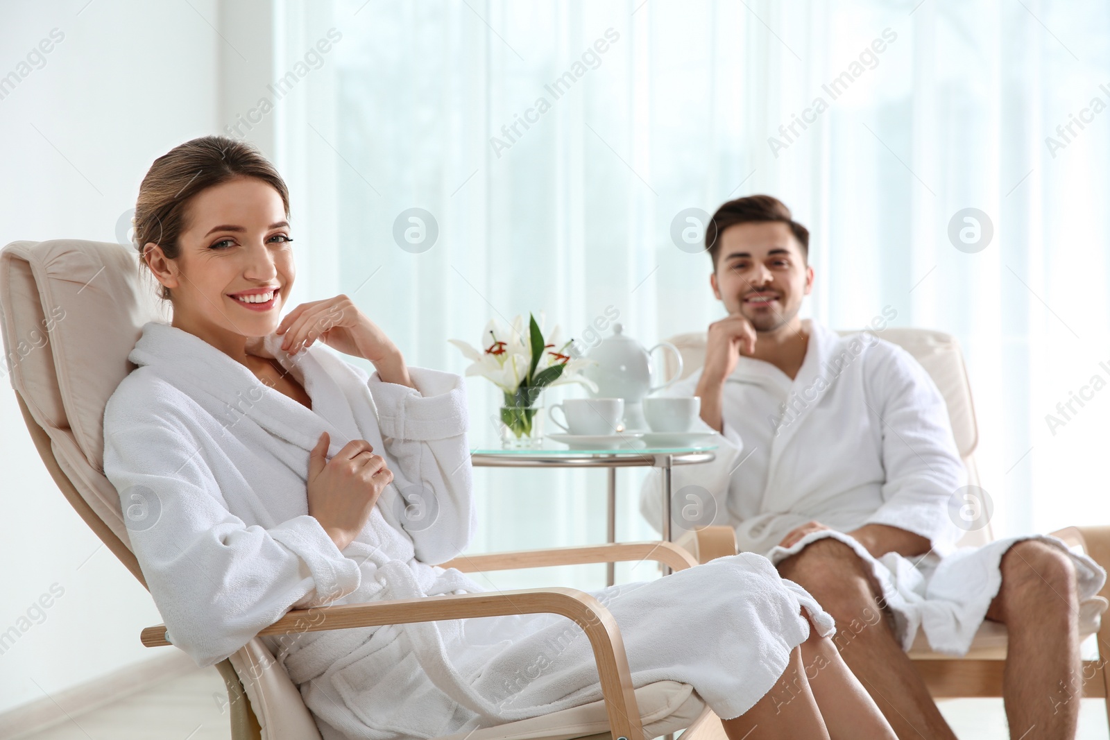 Photo of Romantic young couple with tea in spa salon