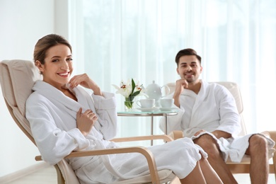 Romantic young couple with tea in spa salon