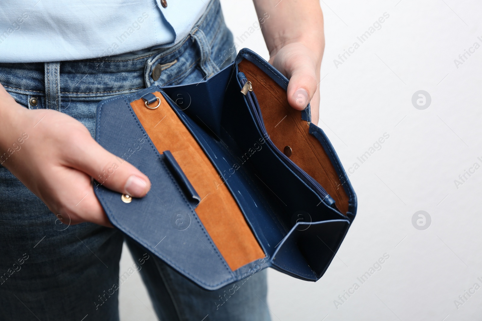 Man showing empty wallet on light background, closeup Photo of Man showing empty wallet on light background, closeup