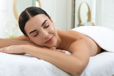 Photo of Beautiful young woman relaxing in spa salon