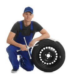 Photo of Portrait of professional auto mechanic with wheel and lug wrench on white background