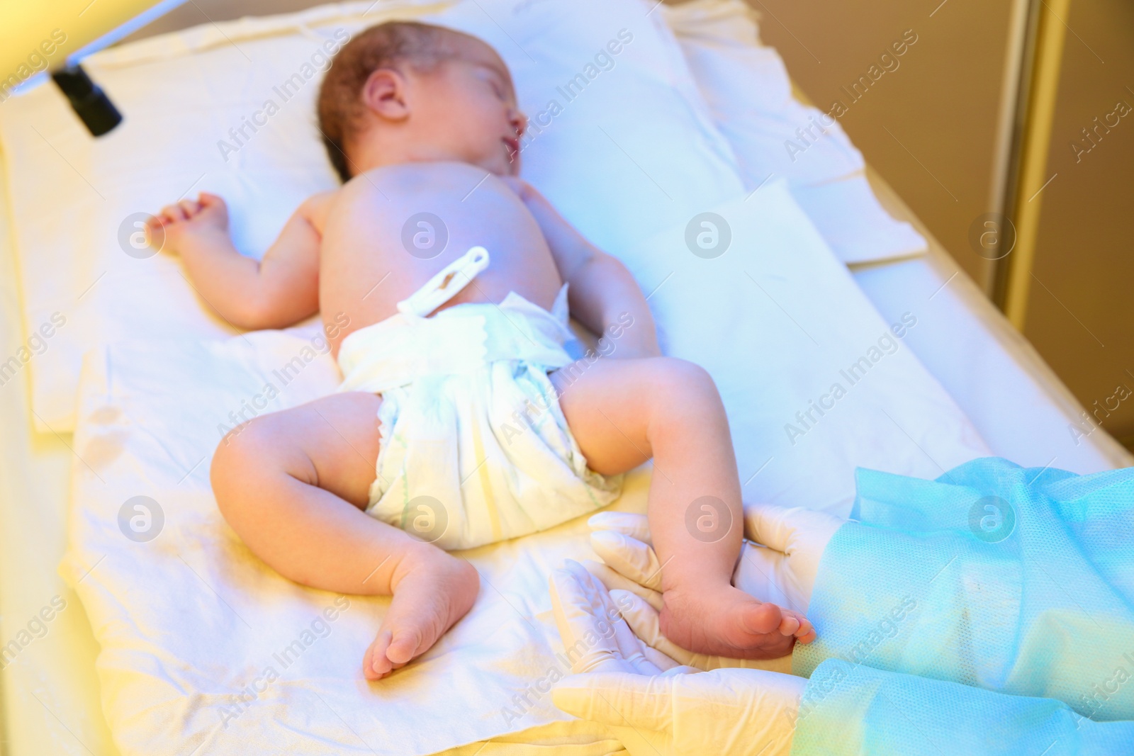 Photo of Doctor holding newborn child's foot in hospital