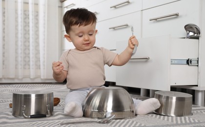 Photo of Cute little boy with cookware at home