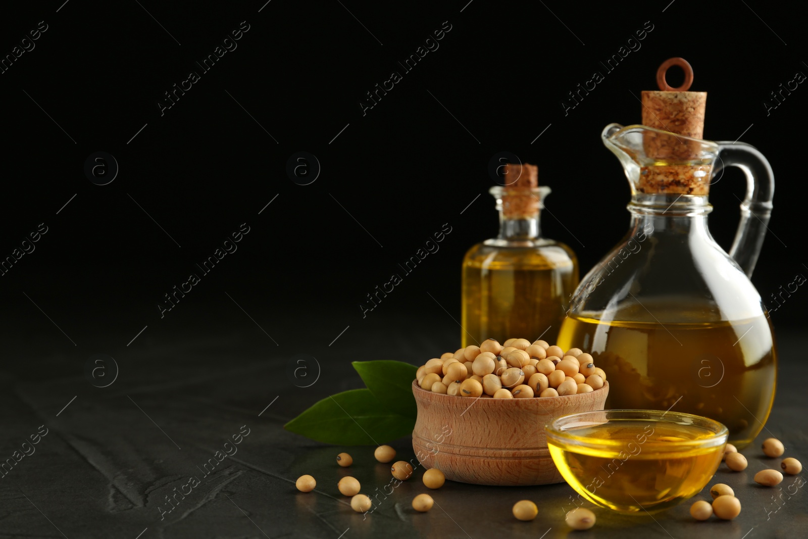 Photo of Composition with soybean oil on grey table, space for text