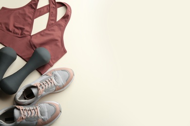 Photo of Flat lay composition with sportswear and equipment on beige background, space for text. Gym workout
