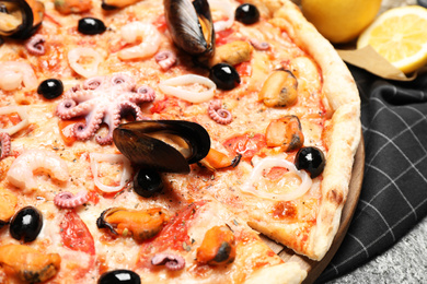 Photo of Tasty fresh pizza with seafood on table, closeup