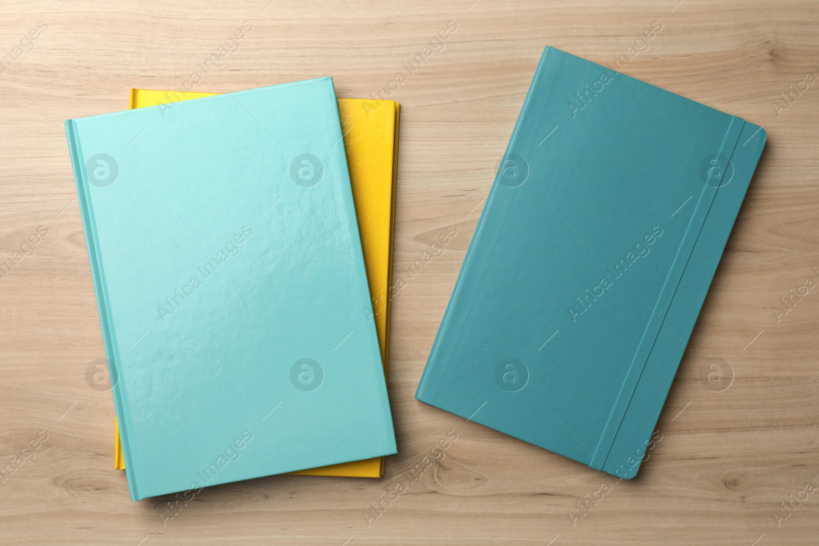 Photo of Different colorful planners on wooden table, flat lay