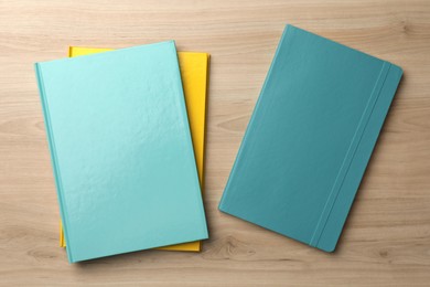 Photo of Different colorful planners on wooden table, flat lay