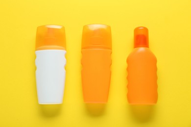 Photo of Suntan products on yellow background, flat lay