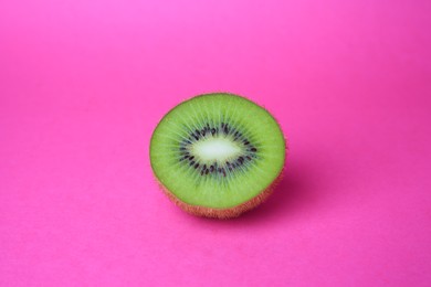 Cut fresh ripe kiwi on pink background