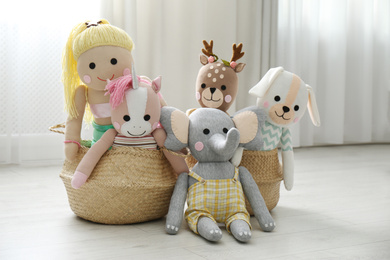 Photo of Funny stuffed toys in baskets on floor. Decor for children's room interior